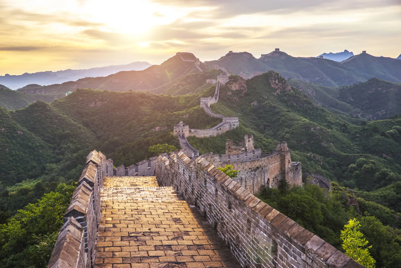 De Chinese Muur slingert over groene bergruggen